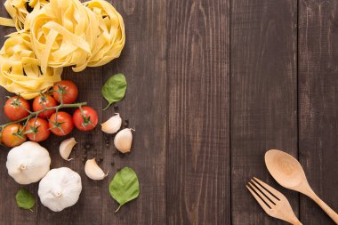 Makarna malzemeler. domates, sarımsak, biber ve mantar ahşap arka plan üzerinde