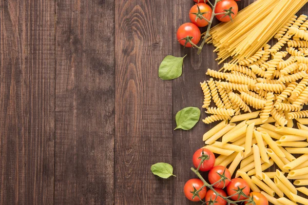 Mixed dried pasta selection on wooden background