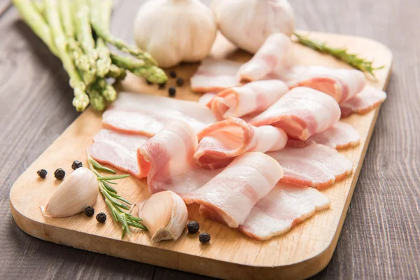 Smoked bacon slices on a wooden table — Stock Photo, Image