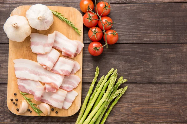 Smoked bacon slices on a wooden table. Top view — Stock Image Smoked bacon slices on a wooden table. Top view Royalty Free Stock Photos