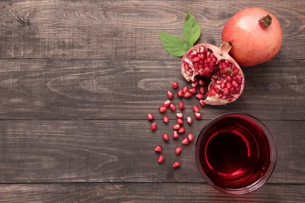 Ripe pomegranates with juice on wooden background