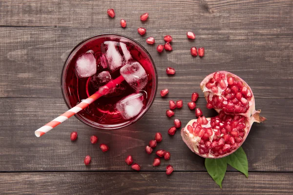 Ripe pomegranates with juice on wooden background — Stock Photo, Image