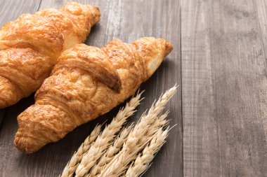 Taze pişmiş tereyağı kruvasan ahşap arka plan üzerinde