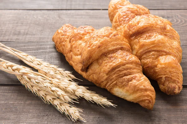 Freshly baked butter croissant on wooden background — Stock Photo, Image