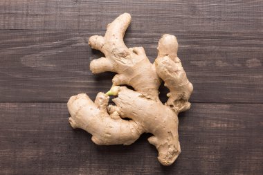 Ginger root on the wooden background. Top view