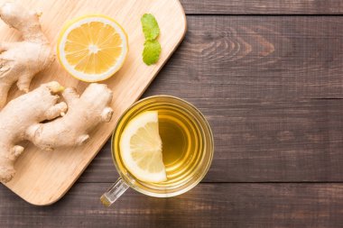 Limon ve ahşap zemin üzerine ballı zencefil çayı fincan