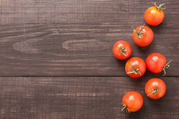 Tomate fraîche sur le fond brun en bois. Vue du dessus — Photo