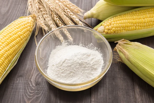 Corn flour and corn on wooden table — Stock Photo, Image