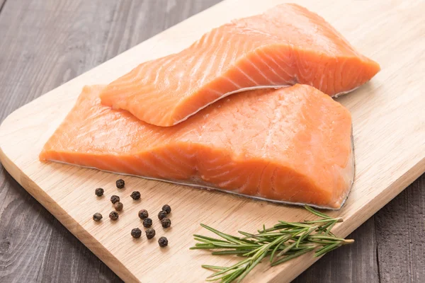 Salmón fresco y pimienta en la mesa de madera — Foto de Stock