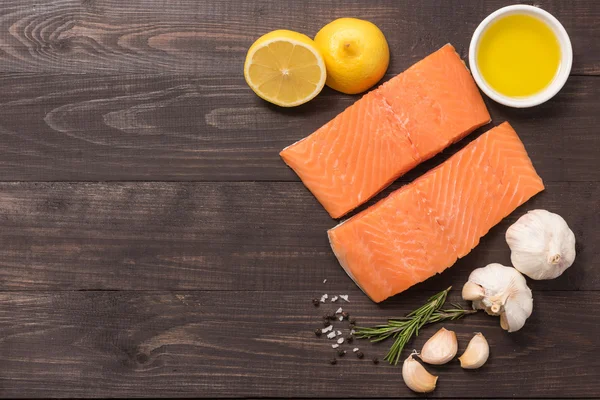 Filete de salmón fresco con especias sobre fondo de madera — Foto de Stock