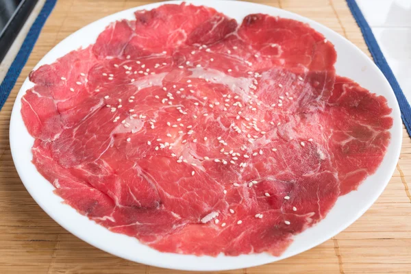 Geser daging sapi mentah pada piring di atas meja — Stok Foto