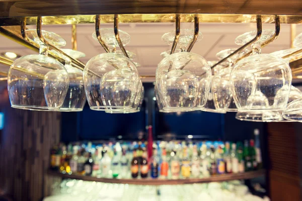 Empty wine glasses on the bar rack, Vintage filter. — Stock Photo, Image