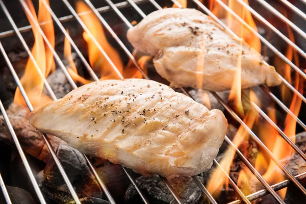 Grilled chicken breast on the flaming grill — Stock Photo, Image