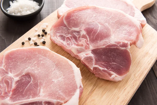 Top view raw fresh meat and salt, pepper on wooden background — Stock Photo, Image