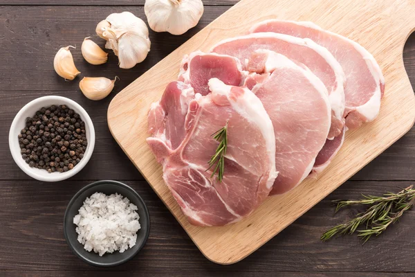 Vista dall'alto carne fresca cruda e sale, pepe, aglio su zaino di legno — Foto Stock