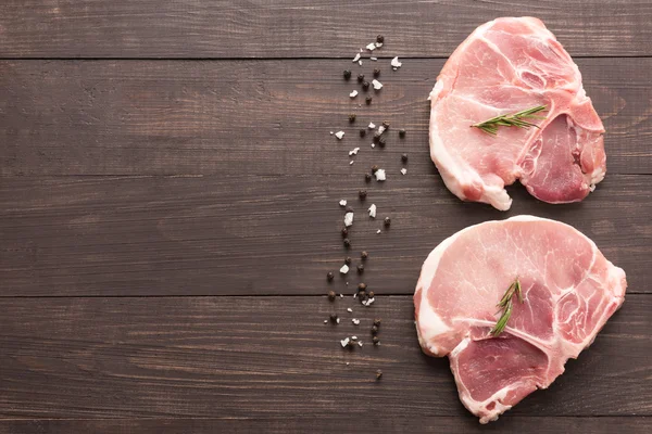 Top view raw pork chop steak and salt, pepper on wooden backgrou — Stock Photo, Image