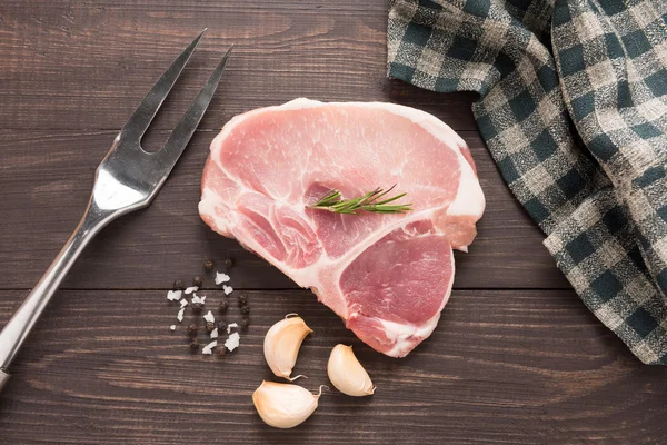 Rohes frisches Fleisch und Salz, Pfeffer, Knoblauch auf Holzrücken — Stockfoto