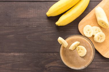 Ahşap arka plan üzerinde muz smoothie. Üstten Görünüm