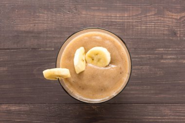 Üst muz smoothie ahşap arka plan üzerine vurdu.