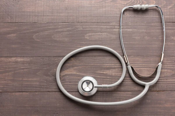 Stethoscope on wooden desk background. Top view. — Stock Photo, Image