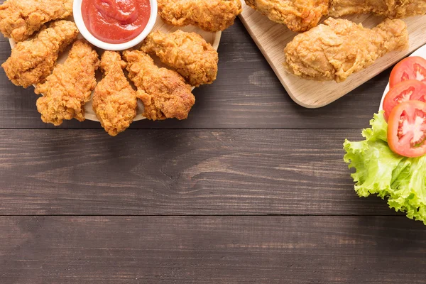 Muslo de pollo frito y verduras sobre fondo de madera —  Fotos de Stock