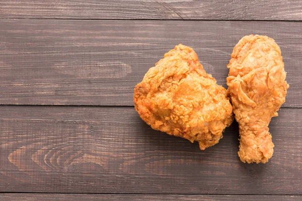 Pechuga de pollo frito y muslo de pollo en un fondo de madera — Foto de Stock