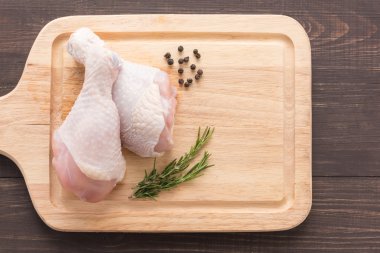 Çiğ tavuk drumsticks ahşap arka plan üzerinde kesme tahtası üzerinde