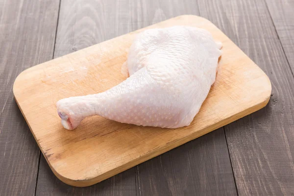 Rauwe kip been op snijplank op houten tafel — Stockfoto