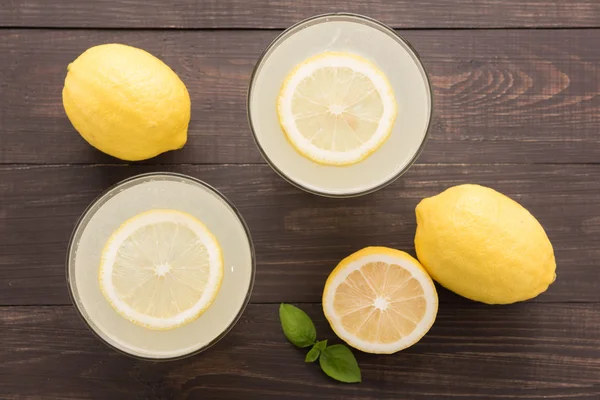 Limonada con limón fresco en rodajas sobre fondo de madera —  Fotos de Stock