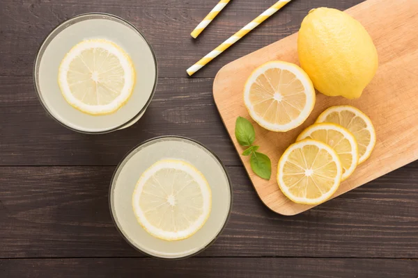 Limonada con limón fresco en rodajas sobre fondo de madera —  Fotos de Stock