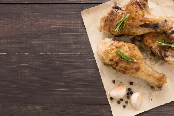 Gegrilde kip drumstick en fruit op houten achtergrond — Stockfoto