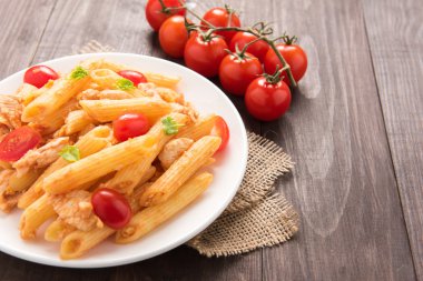 Ahşap bir masa üzerinde tavuk domates soslu Penne makarna
