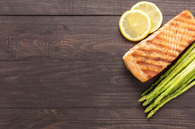 Limonlu ızgara somon, kuşkonmaz ahşap arka plan üzerinde