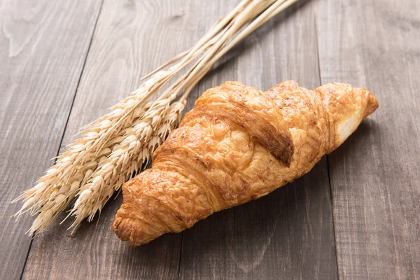 Croissant de mantequilla recién horneada sobre mesa de madera — Foto de Stock