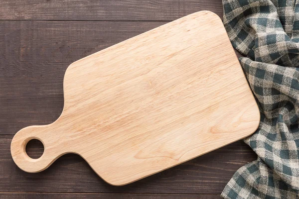 Tabla de cortar con servilleta sobre fondo de madera — Foto de Stock