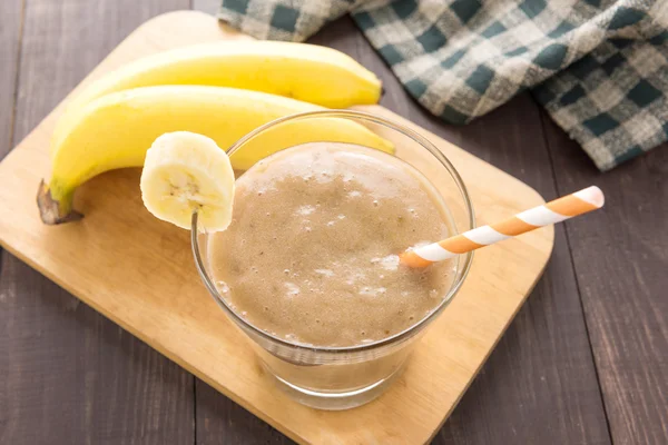 Banana smoothie i świeżych bananów na drewniane tła. Widok z góry. — Zdjęcie stockowe