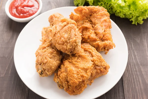 Gebakken kip drumstick en groenten op houten tafel — Stockfoto