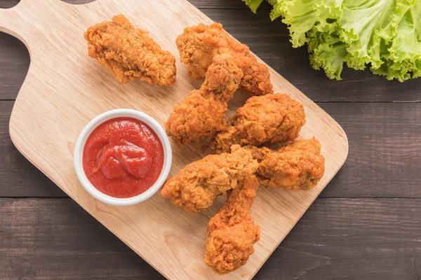 Podudzie kurczaka smażone i ketchupem na drewnianym stole — Zdjęcie stockowe