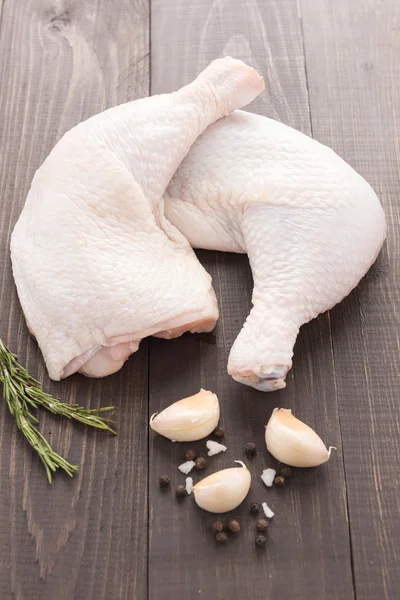 Rauwe kip been en peper, zout, knoflook op houten achtergrond — Stockfoto