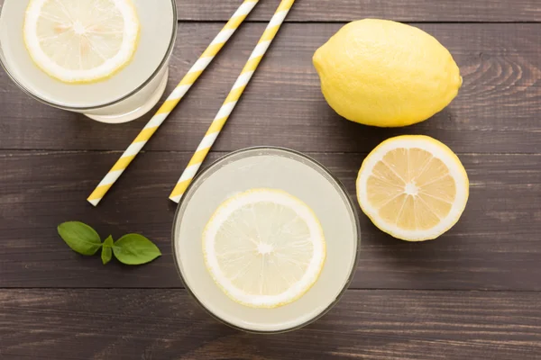 Limonada con limón fresco en rodajas sobre fondo de madera —  Fotos de Stock