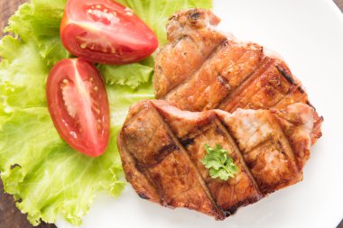 Beyaz bir tabak üzerinde sebzeli ızgara biftek