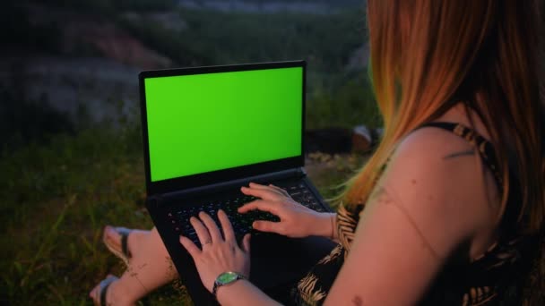 Młoda dziewczyna pracuje na laptopie z zielonym ekranem na szczycie góry. — Wideo stockowe