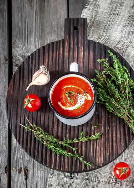 Kremalı domates çorbası kupa ve kekik bir ahşap tablo. 