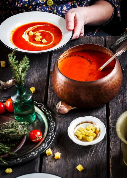 Grädde tomatsoppa med krutonger i kvinnliga händer. — Stockfoto