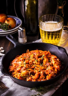 Vintage bir kızartma tavası ve bir kupa bira ile haşlanmış lahana. 
