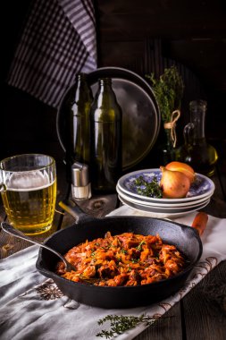 Vintage bir kızartma tavası ve bir kupa bira ile haşlanmış lahana.