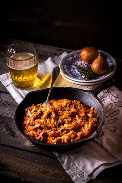 Col cocida en una sartén de la vendimia y una taza con cerveza . — Foto de Stock