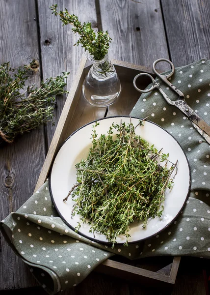 Thyme in vintage plate, napkin and scissors in wooden box . — стоковое фото