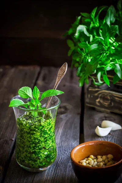 Pesto al basilico in vetro sul tavolo di legno . — Foto Stock