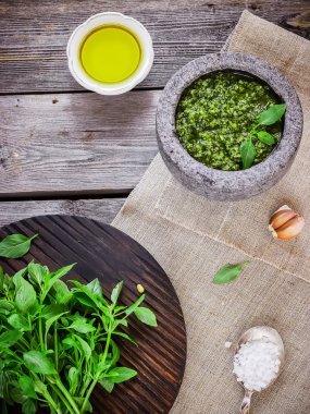 Ahşap doğrama tahtası, ahşap masa üzerinde mermer harç pesto üzerinde taze fesleğen. 
